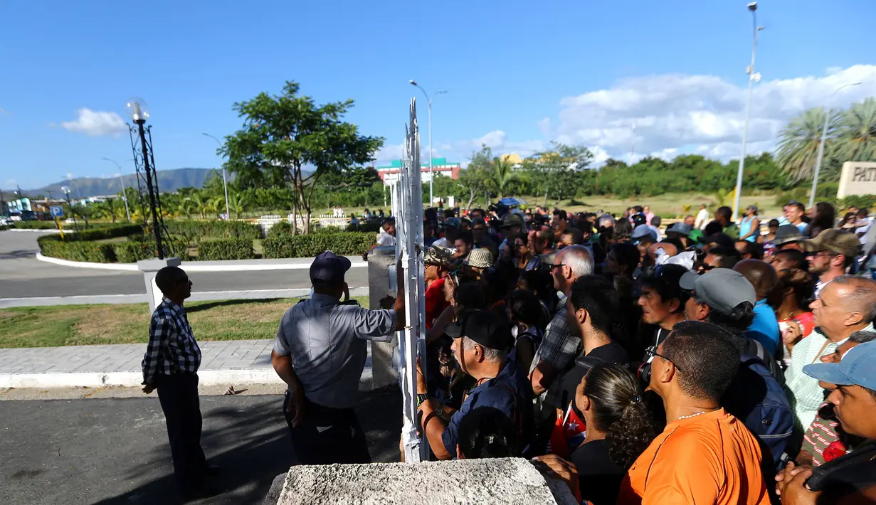 Warga Kuba saat menyaksikan pemakaman abu mantan Presiden Kuba, Fidel Castro di Santa Ifigenia Cemetery di Santiago, Kuba (4/12). Fidel Castro meninggal pada usia 90 tahun. (REUTERS/Ivan Alvarado)