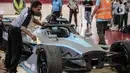 Petugas mengelap replika mobil Formula E setelah dibuka untuk kali pertama di Stadion Balap Sepeda Velodrome, Rawamangun, Jakarta Timur, pada Kamis (26/5/2022). Ini merupakan replika salah satu mobil Formula E yang akan mengaspal di Sirkuit Ancol pada 4 Juni mendatang. (Liputan6.com/Faizal Fanani)
