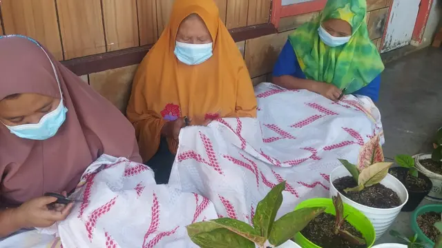 Nampak emak-emak anggota kelompok Usaha Tenun Sutera Alam Mardian Putera, Tasikmalaya, tengah memola motif kain sutera kelompoknya, dari suntikan modal CRS Pertamina.