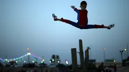 Aksi akrobat Mohammed al Sheikh melompat ke atas, di sebuah pantai di Kota Gaza, Palestina, Kamis (2/6). Remaja 12 tahun itu menyatakan keinginannya untuk mencetak rekor dunia Guinness World Record yang baru. (REUTERS/Mohammed Salem)
