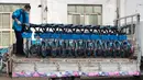 Seorang staf memindahkan sepeda listrik untuk layanan berbagi kendaraan dari truk ke area parkir di Distrik Fancheng di Kota Xiangyang, Provinsi Hubei, China tengah (24/4/2020). (Xinhua/Xie Jianfei)