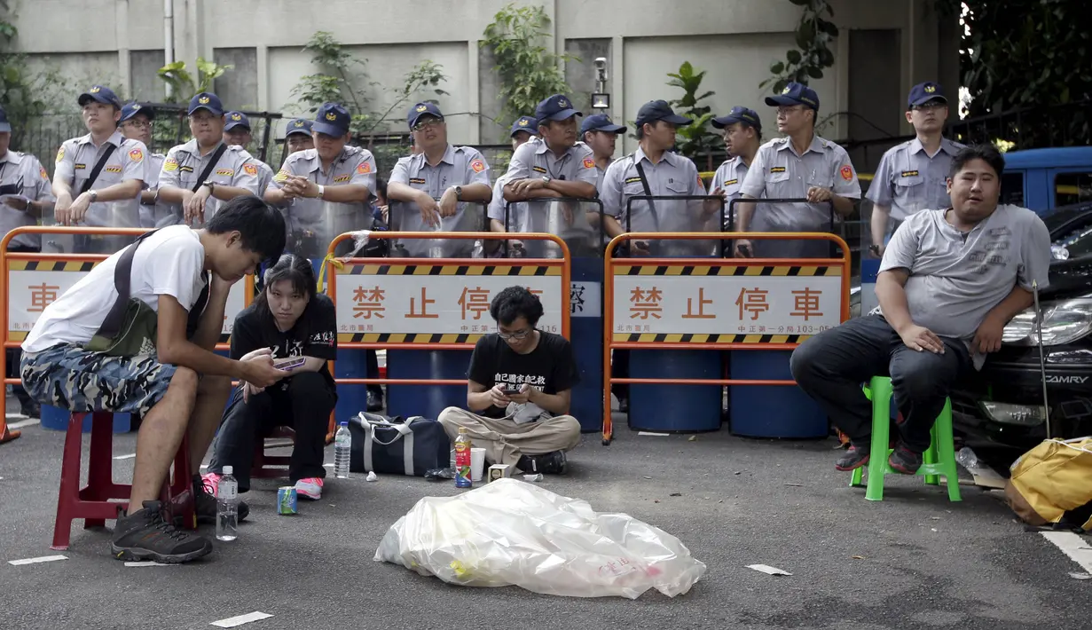 Kepolisian menjaga Pelajar yang menggelar aksi protes anti-China di sekitar Gedung Kementerian Pendidikan,Taipei, Taiwan, Jumat (31/7/2015). Ratusan pelajar Taiwan turun ke jalan menuntut pengunduran diri menteri pendidikan Taiwan. (REUTERS/Pichi Chuang)