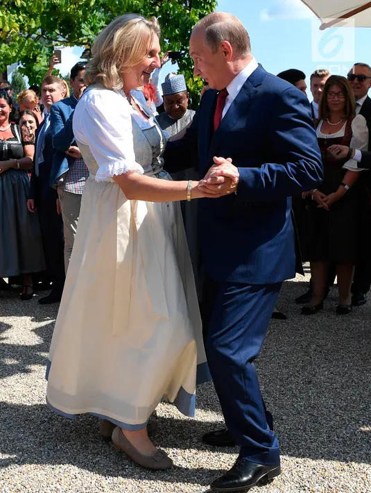 Presiden Rusia, Vladimir Putin memamerkan kemampuan berdansa ketika menghadiri pesta pernikahan Menteri Luar Negeri Austria, Karin Kneissl dengan pengusaha Wolfgang Meilinger di Gamlitz, Austria selatan, Sabtu (18/8). (Roland Schlager/pool Photo via AP)
