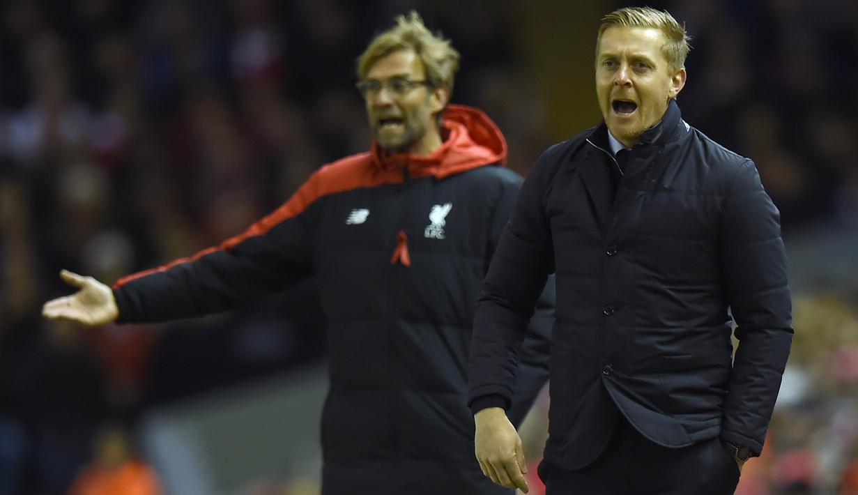 Pelatih Liverpool, Jurgen Klopp (kiri) dan Pelatih Swansea City, Garry Monk memberikan instruksi kepada anak asunya, pada lanjutan Liga Premier Inggris di Stadion Anfiled, Senin (30/11/2015) dini hari WIB. (AFP Photo/Paul Ellis)