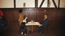 Patung lilin Audrey Hepburn dan Michael Strahan menempati salah satu meja di Peter Luger Steakhouse di New York, Jumat (26/2/2021). Patung yang dipinjam dari Madame Tussauds itu membantu mengisi meja kosong yang tidak digunakan selama pelonggaran pembatasan aturan COVID-19.  (AP Photo/Kevin Hagen)