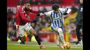 Pemain Brighton, Kaoru Mitoma (kanan) menggiring bola dibayangi pemain Manchester United, Noussair Mazraoui pada laga lanjutan Liga Inggris 2024/2025 yang berlangsung di Old Trafford, Manchester, Inggris, Minggu (19/01/2025). (AP Photo/Dave Thompson)
