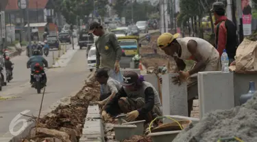 Pekerja saat menyelesaikan proyek rehabilitasi ruas jalan Ciputat-Pamulang, Tangerang Selatan, (28/1). Pemerintah Provinsi Banten akan melakukan rehab pada beberapa titik ruas jalan yang menghabiskan lebih dari Rp 21 miliar. (Liputan6.com/Faisal R Syam)