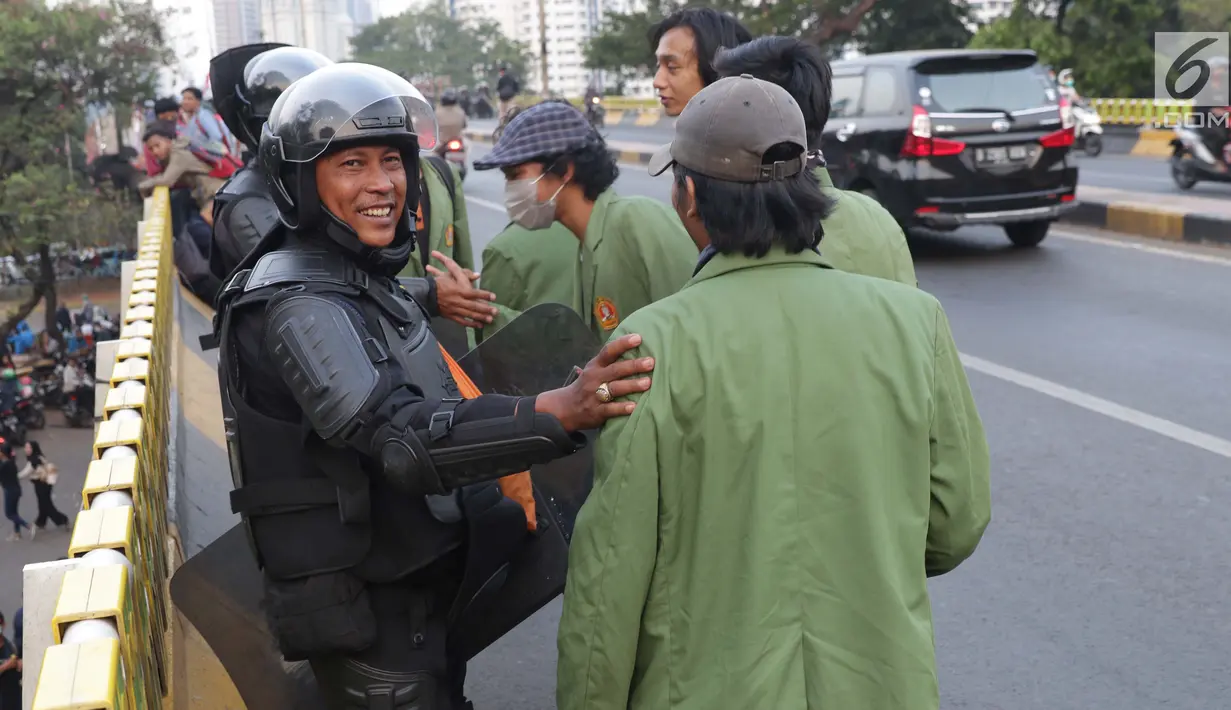 Mahasiswa dari salah satu perguruan tinggi bersalaman dengan personel Brimob usai melakukan aksi unjuk rasa di sekitar Jembatan Layang Gerbang Pemuda, Jakarta, Selasa (1/10/2019). Mahasiswa dari berbagai perguruan tinggi kembali berunjuk rasa menolak beberapa RUU. (Liputan6.com/Helmi Fithriansyah)