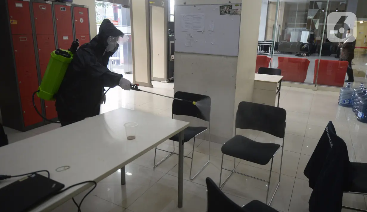 Petugas menyemprotkan cairan disinfektan di Press Room Gedung KPK, Jakarta, Jumat (5/6/2020). Langkah tersebut sebagai upaya preventif pencegahan penularan virus corona COVID-19 jelang new normal di tengah pandemi. (merdeka.com/Dwi Narwoko)