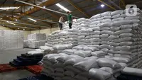 Pekerja menata tumpukan karung berisi beras di Gudang RPC Food Station Tjipinang Jaya, Jakarta Timur, Sabtu (22/2/2025). (Liputan6.com/Herman Zakharia)