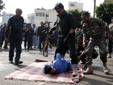 Pasukan keamanan bersiap mengeksekusi pria bernama Hussein al-Saket 22 tahun akibat memperkosa dan membunuh seorang gadis berusia empat tahun di alun-alun Tahrir, Ibu Kota Sanaa, Yaman (14/8). (AFP Photo/Mohammed Huwais)