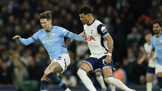 Duel John Stones vs Dominic Solanke dalam laga Manchester City vs Tottenham di pekan ke-12 Premier League 2024/2025. (c) AP Photo/Dave Thompson