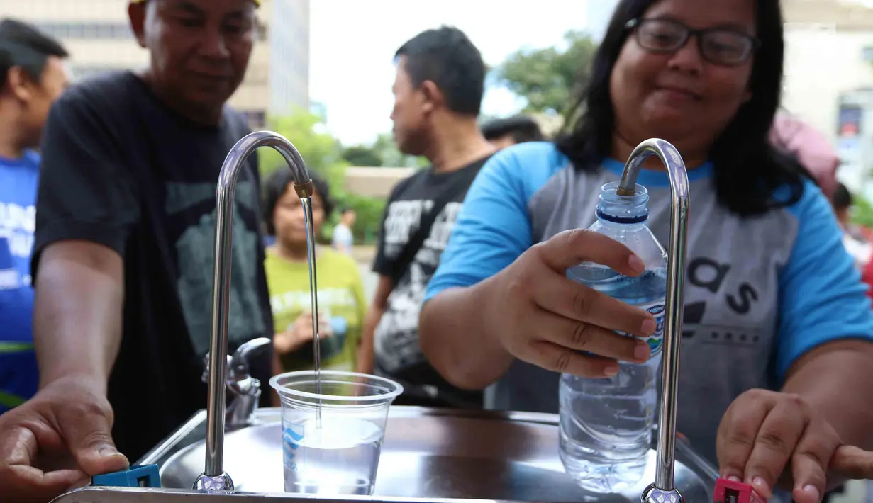 Warga mengambil air minum gratis saat run for water di CFD, Jakarta, Minggu (25/3). Run For Water kolaborasi PAM Jaya, Palyja, dan Aetra mengkampanyekan Hari Air Dunia 2018 mengajak masyarakat ayo peduli air Jakarta. (Liputan6.com/Angga Yuniar)