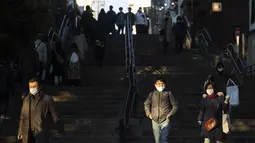 Orang-orang yang memakai masker wajah berjalan ke bawah menuju Taman Inokashira di Mitaka, barat Tokyo, Jepang, Jumat (29/1/2021). Olimpiade 2020 Tokyo yang ditunda terkait pandemi virus corona Covid-19 dijadwalkan ulang untuk diadakan pada musim panas ini. (AP Photo/Hiro Komae)