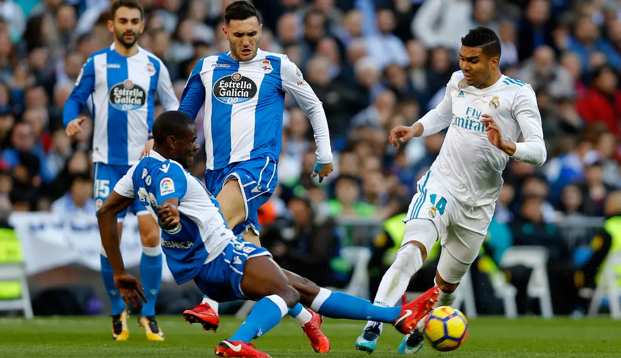 Pemain Real Madrid, Casemiro berebut bola dengan pemain Deportivo La Coruna, Aldo dalam lanjutan La Liga Spanyol di Santiago Bernabue, Senin (22/1). Real Madrid membukukan kemenangan 7-1 atas Deportivo La Coruna. (AP/Francisco Seco)