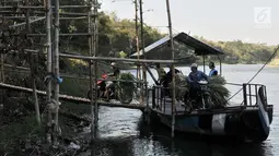 Pengendara sepeda motor membawa pakan ternak saat menyeberangi Sungai Brantas menaiki perahu eretan di Desa Mayan, Mojo, Kediri, Sabtu (29/9). Meski sudah ada jembatan, warga memilih perahu eretan sebagai penunjang aktivitas. (Merdeka.com/Iqbal Nugroho)
