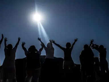Para jemaah mengangkat tangan mereka ke arah matahari di piramida Teotihuacan di kota San Juan Teotihuacan, Negara Bagian Meksiko, saat perayaan equinoks musim semi pada 21 Maret 2024. (CARL DE SOUZA/AFP)
