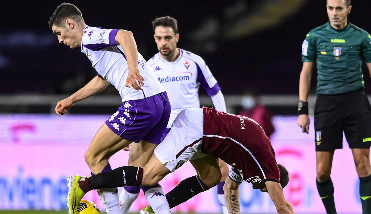 Striker Fiorentina, Dusan Vlahovic (kiri) berebut bola dengan striker Torino, Andrea Belotti dalam laga lanjutan Liga Italia 2020/21 pekan ke-20 di Olympico Grande Stadium, Jumat (29/1/2021). Fiorentina bermain imbang 1-1 dengan Torino. (LaPresse via AP/Fabio Ferrari)