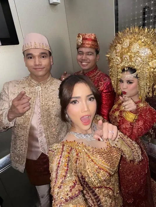 Indah memilih kebaya merah marun yang sarat akan detail artistik. Kebaya rancangan Laviena Wedding Gallery ini menghadirkan siluet klasik yang dipadu dengan sentuhan modern lewat taburan payet emas yang tertata rapi di seluruh permukaan kain. [@indahtrp].