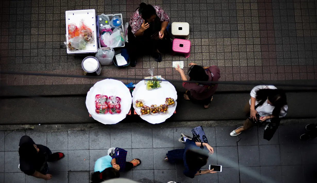 Pedagang buah-buahan melayani pelanggan di Bangkok, Thailand (20/9). Bangkok dikenal punya sejarah panjang sebagai pusat makanan jalanan di dunia. (AFP Photo/Jewel Samad)