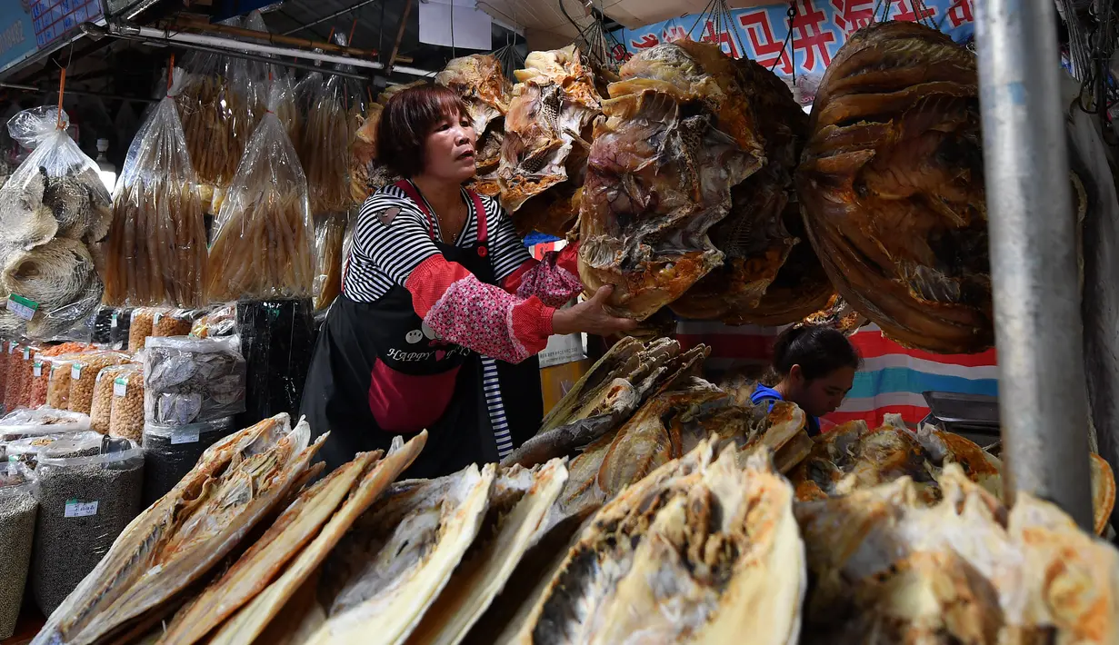 Penjual menata makanan laut kering di sebuah pasar di Kota Haikou, Provinsi Hainan, China, Rabu (15/1/2020). Warga Haikou akhir-akhir ini sibuk berbelanja untuk menyambut Tahun Baru Imlek 2020. (Xinhua/Guo Cheng)