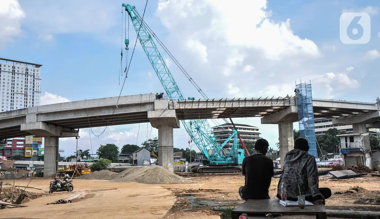 Warga menyaksikan proyek pembangunan Jalan Tol Bekasi-Cawang-Kampung Melayu (Becakayu) Seksi 1, D.I Panjaitan, Jakarta, Kamis (18/11/2021). BPJT mendata hingga akhir kuartal III/2021 perkembangan pembangunan Tol Becakayu Seksi 1 saat ini mencapai 95,54 persen. (merdeka.com/Iqbal S Nugroho)