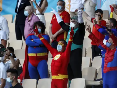 Suporter Spanyol berpakaian adu banteng, mengibarkan bendera negaranya di luar arena adu banteng Plaza de Toros, di Seville, Spanyol, Sabtu, 19 Juni 2021. Spanyol akan menghadapi Polandia pada Sabtu malam untuk Grup E Euro 2020. (AP Photo/Thanassis Stavrakis)