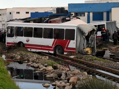 Sebuah kereta menghantam bus yang melintas di rel dekat wilayah Sidi Fathallah, sekitar 10 km selatan Ibu Kota Tunisia, Rabu (28/12). Bus itu terbelah dua ketika dihantam kereta dan menyebabkan lima orang tewas serta 34 lainnya terluka. (Fethi Belaid/AFP)