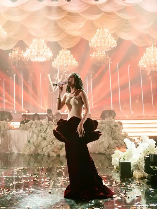 Lyodra tampil dengan gaun dari Jessie Gunawan Studio. Gaun tersebut memiliki siluet seperti bunga mawar terlihat dari rok panjang maroon berbahan velvet dengan bagian atas rok bersiluet kelopak bunga.  [@lyodraofficial]