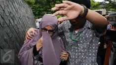 Istri Hakim MK Patrialis Akbar, Sufriyeni (kiri) menutup wajah saat menuju ruang tahanan KPK, Jakarta, Senin (30/1). Patrialis Akbar menjadi tersangka dugaan penerima suap uji materi UU peternakan dan Kesehatan Hewan. (Liputan6.com/Helmi Fithriansyah)