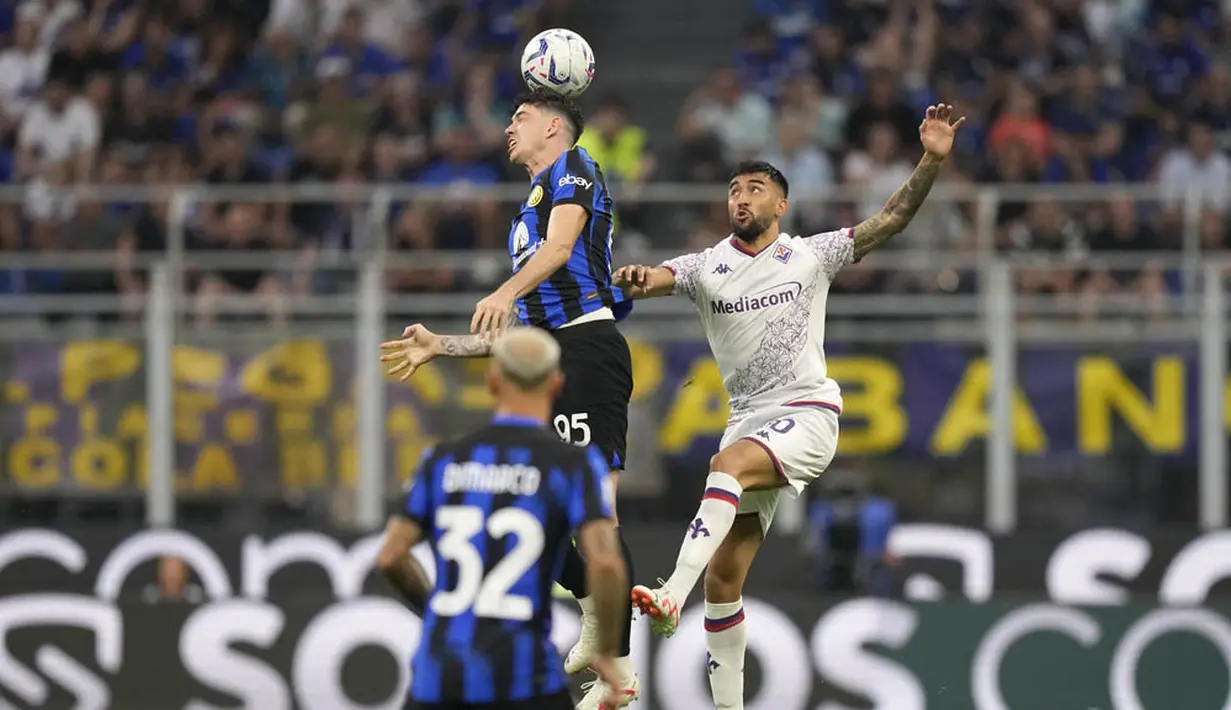 Pemain Inter Milan, Alessandro Bastoni, duel udara dengan pemain Fiorentina, Nicolas Gonzalez, pada laga Liga Italia pekan ketiga Serie A 2023/2024 di Stadion Giuseppe Meazza, Minggu (03/09/2023). Inter Milan menang dengan skor 4-0. (AP Photo/Antonio Calanni)