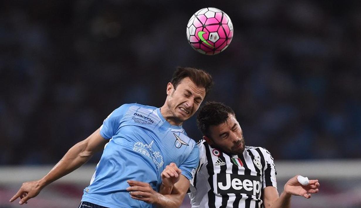 Striker Juventus, Andrea Barzagli (kanan) berebut bola dengan pemain Lazio, Stefan Radu, dalam final Piala Super Italia 2015 di Stadion Shanghai, Tiongkok. Sabtu (8/8/2015). (AFP Photo/Johanne Eisele)