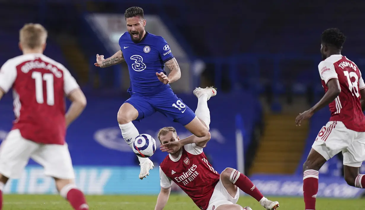 Striker Chelsea, Olivier Giroud (atas) melompat menghindari tekel bek Arsenal, Rob Holding dalam laga lanjutan Liga Inggris 2020/2021 pekan ke-35 di Stamford Bridge, London, Rabu (12/5/2021). Chelsea kalah 0-1 dari Arsenal. (AP/Adam Davy/Pool)
