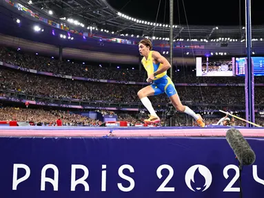 Atlet Swedia, Armand Duplantis merayakan rekor dunia baru dengan lompatan setinggi 6,25 meter dalam final lompat galah putra Olimpiade Paris 2024 di Stade de France, Senin (5/8/2024). (Kirill KUDRYAVTSEV / AFP)