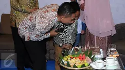 Bupati Batang, Yoyok Riyo Sudibyo bersama sang anak meniup lilin saat mendapat kejutan dari istri dan kedua anaknya usai berbicara pada seminar Kekuatan Perempuan Inspirasi Perubahan di Jakarta, Sabtu (23/4/2016). (Liputan6.com/Helmi Fithriansyah)