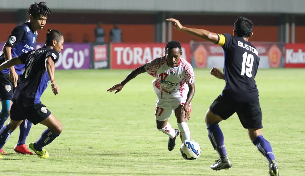 Pemain Persipura, Ferinando Pahabol, berusaha melewati pemain Arema Cronus, Ahmad Bustomi, pada babak 8 besar Piala Jenderal Sudirman di Stadion Maguwoharjo, Sleman, Minggu (13/12/2015). (Bola.com/Nick Hanoatubun)