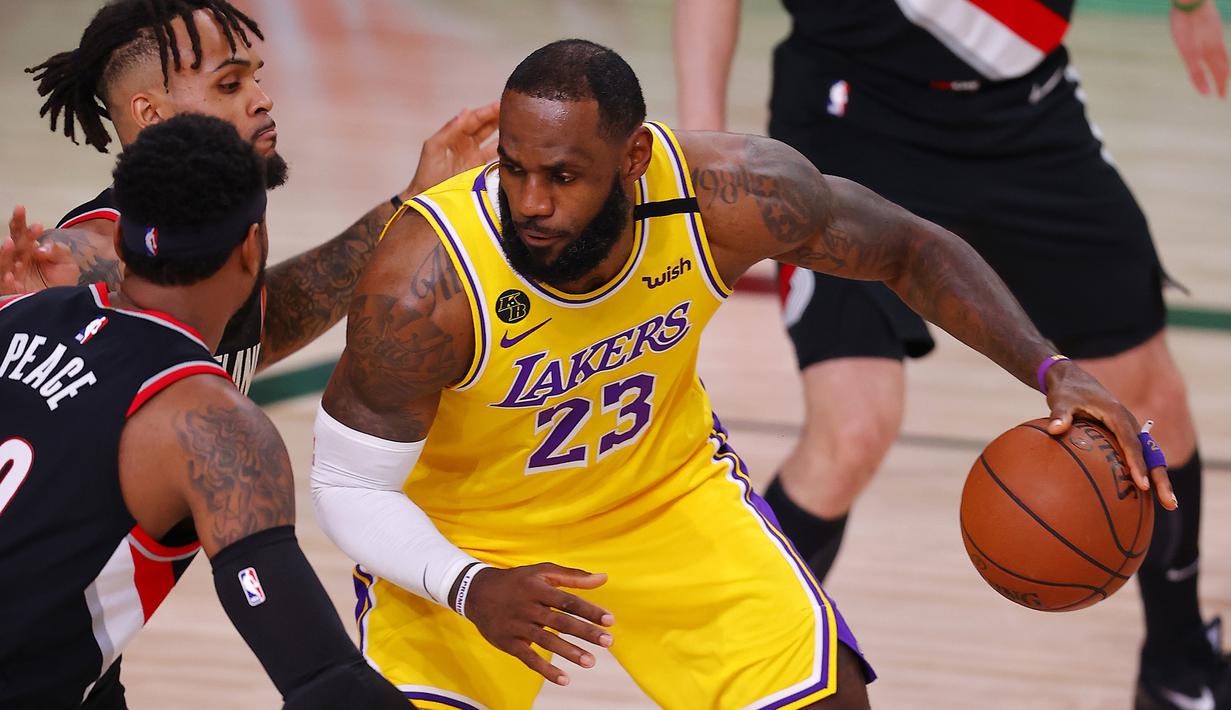 Pebasket Los Angeles Lakers, LeBron James, berusaha melewati pemain Portland Trailblazers pada babak pertama playoff NBA 2020 di AdventHealth Arena, Rabu (19/8/2020). LA Laker takluk 93-100 atas Portland Trailblazers. (AFP/Mike Ehrmann/Getty Images)