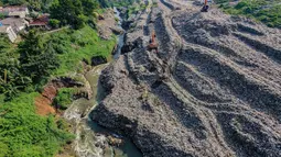 Kondisi aliran Kali Pesanggrahan yang menyempit di kawasan Pasir Putih, Depok, Jawa Barat, Senin (27/4/2026), setelah longsoran sampah dari Tempat Pembuangan Akhir (TPA) Cipayung menutup sebagian badan sungai. (merdeka.com/Arie Basuki)