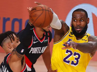 Pebasket Los Angeles Lakers, LeBron James, berebut bola dengan pebasket Portland Trailblazers,  Gary Trent Jr, pada babak pertama playoff NBA 2020 di AdventHealth Arena, Rabu (19/8/2020). LA Lakers takluk 93-100 atas Portland Trailblazers. (AFP/Mike Ehrmann/Getty Images)