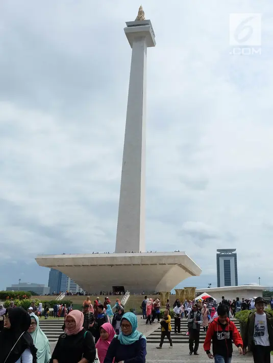 Sejumlah pengunjung saat sedang liburan di Monumen Nasional (monas), Jakarta, Selasa (25/12). Liburan Natal 2018, banyak warga datang bersama kerabat maupun keluarga memadati Monas. (Liputan6.com/Herman Zakharia)