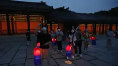 Pengunjung memegang lentera tradisional Korea berjalan-jalan selama Tur Cahaya Bulan di Istana Changdeokgung di Seoul, Korea Selatan, Kamis, (13/8/2020). Istana dibuka kembali pada Kamis setelah ditutup selama dua bulan karena pandemi Covid-19. (AP Photo/Ahn Young-joon)