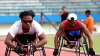 Doni Yulianto (kiri) dan Joko Sriyono berlatih dengan menggunakan kursi rodanya di Stadion Manahan, Solo, Jateng, Selasa (20/4) untuk kejurnas atletik penyandang cacat bulan Juli mendatang. (Antara)