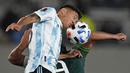 Bek Argentina, Nahuel Molina berebut bola dengan penyerang Bolivia, Marcelo Martins pada Kualifikasi Piala Dunia 2022 zona Amerika Selatan, di Stadion El Monumentttal, Jumat (10/9/2021). Hat-trick Lionel Messi membuat Argentina menang 3-0 atas Bolivia. (Natacha Pisarenko/POOL/AFP)