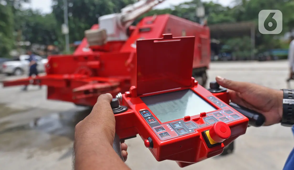 Petugas pemadam kebakaran mengoperasikan robot damkar jenis Dok-INK MVF- U3 di kantor PKP DKI Jakarta, Kamis (13/2/2020). Dinas Penanggulangan Kebakaran dan Penyelamatan (PKP) DKI Jakarta membeli robot pemadam kebakaran Dok-ing MVF-U3 senilai Rp 37,4 miliar. (Liputan6.com/Herman Zakharia)