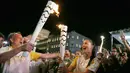 Supermodel Adriana Lima dan Sekretaris Pariwisata kota Rio De Janeiro, Antonio Pedro ketika membawa obor pada malam penyambutan Olimpiade Rio 2016 di Maua Square Rio de Janeiro, Brasil, Kamis (4/8). (REUTERS / Pilar Olivares)