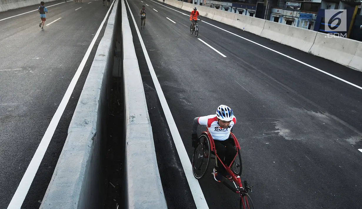 Peserta mengayuh kursi rodanya saat mengikuti perlombaaan lari 5K dan 10K dalam kegiatan Bogor Running Race di jalan Tol Bogor Outer Ring Road (BORR), Bogor (01/04). (Merdeka.com/Arie Basuki)