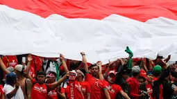 Suporter Timnas Indonesia U-22 membentangkan bendera merah putih saat menyaksikan pertandingan melawan Thailand di SEA Games 2017 di Shah Alam, Malaysia (15/8). Indonesia dan Thailand bermain imbang 1-1. (AP Photo / Vincent Thian)