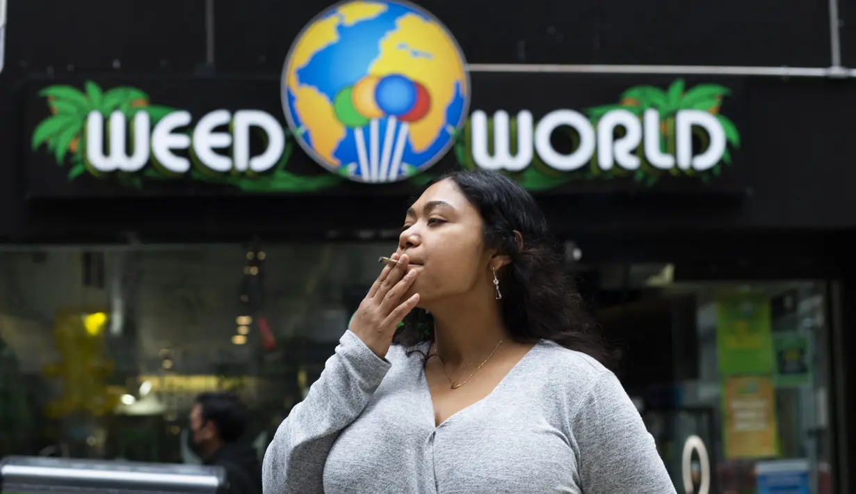 Pelanggan mengisap ganja yang dijual bebas di toko Weed World di New York (31/3/2021). Pengesahan tersebut dibuat setelah Gubernur New York Andrew Cuomo menandatangani undang-undang yang melegalkan ganja pada 31 Maret 2021. (AFP/Kena Betancur)