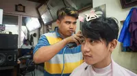 Gibran Rakabuming Raka di sela blusukan menyempatkan untuk potong rambut di tukang cukur Madura.(Liputan6.com/Fajar Abrori)