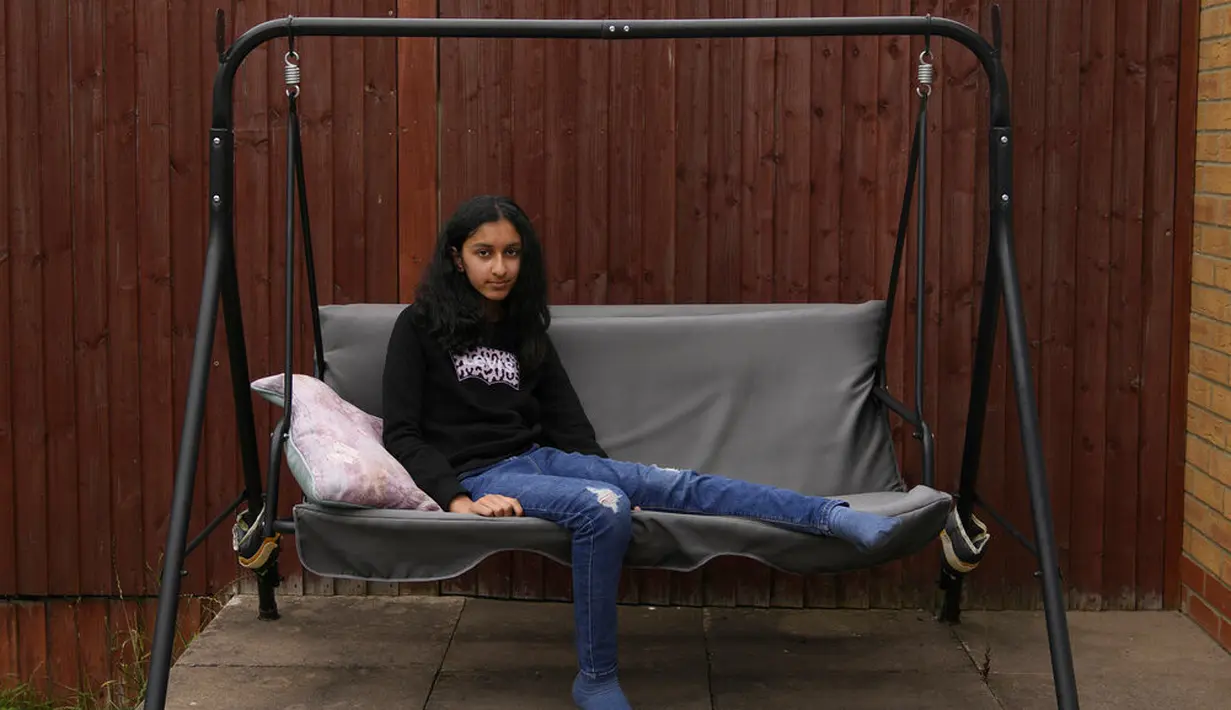Niva Thakrar (13) yang kehilangan ayahnya karena virus corona Covid-19, berpose di rumahnya di barat laut London, 5 Juli 2021. "Saya masih mencoba melakukan apa yang biasa kami lakukan sebelumnya, tetapi itu tidak sama," kata Thakrar. (AP Photo/Thanassis Stavrakis)